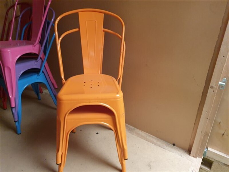Orange Tolix style metal café chairs