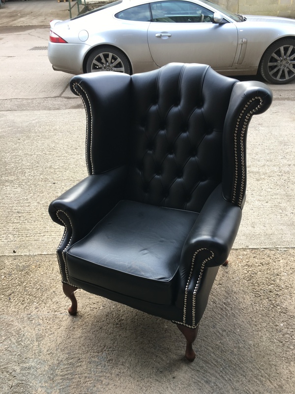 Black leather Chesterfieldstyle wingback armchairs