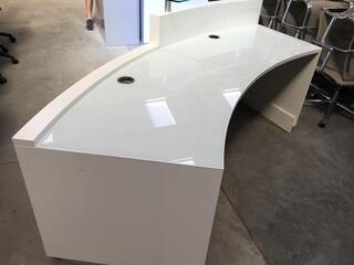 White curved reception desk